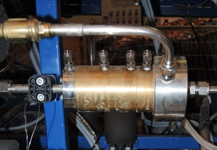 mbulle_ejektor.jpg Diese Abbildung zeigt den Ejektor eingebunden in die transkritische CO2-Kälteanlage. CO2 wird von Hochdruck (Anschluss rechts) auf Mitteldruck (An-schluss links) entspannt und zugleich flüssiges CO2 von Saugdruck (Anschluss oben) auf Mitteldruck gepumpt.